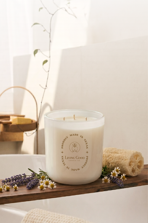 Living Good Candle Co. 15 oz Tranquility three-wick beeswax candle styled with lavender and chamomile in a relaxing spa-like setting.