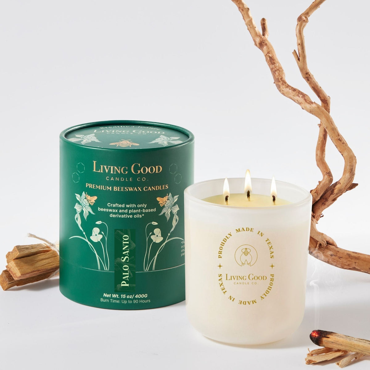 Living Good Candle Co. 15 oz Palo Santo three-wick beeswax candle with packaging and Palo Santo wood in a clean studio setting.