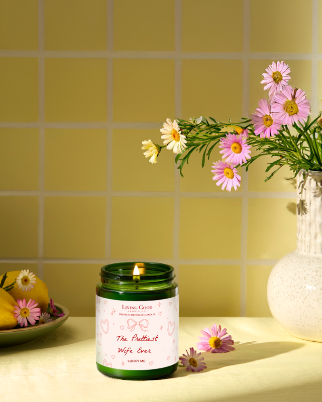 Living Good Candle Co. 5.5 oz personalized beeswax candle with “The Prettiest Wife Ever” label styled with flowers for Valentine’s Day.