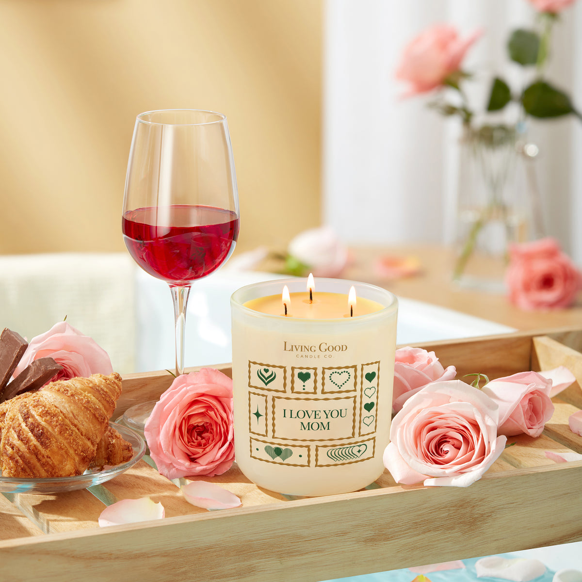 I Love You Mom beeswax candle with roses, croissant, and drink arranged as a thoughtful gift for Mom.