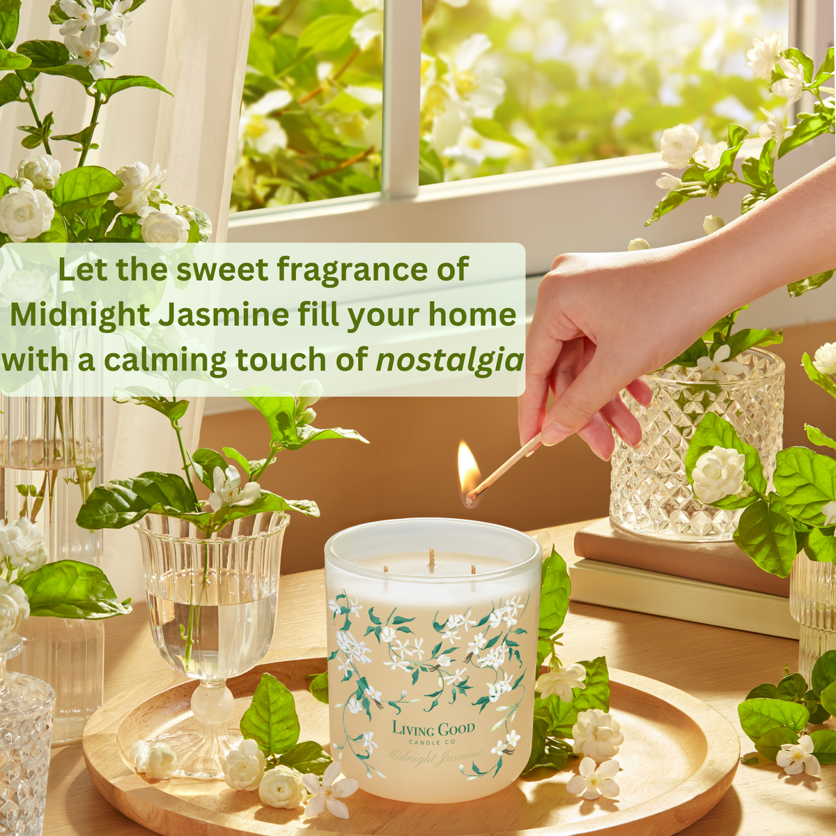 Midnight Jasmine beeswax candle being lit in a bright home setting with blooming jasmine flowers and soft natural light.