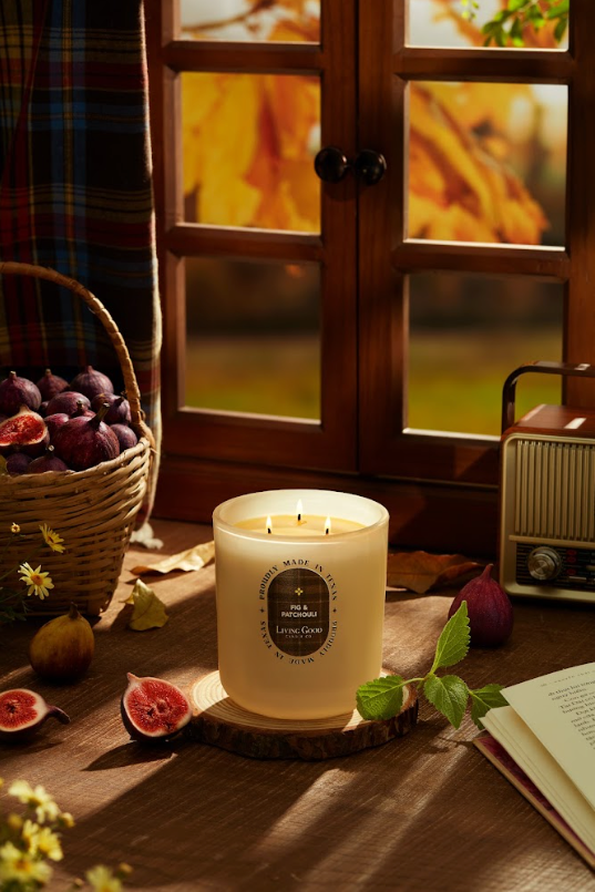 Living Good Candle Co. Fig & Patchouli beeswax candle with fresh figs in a warm, cozy fall setting.