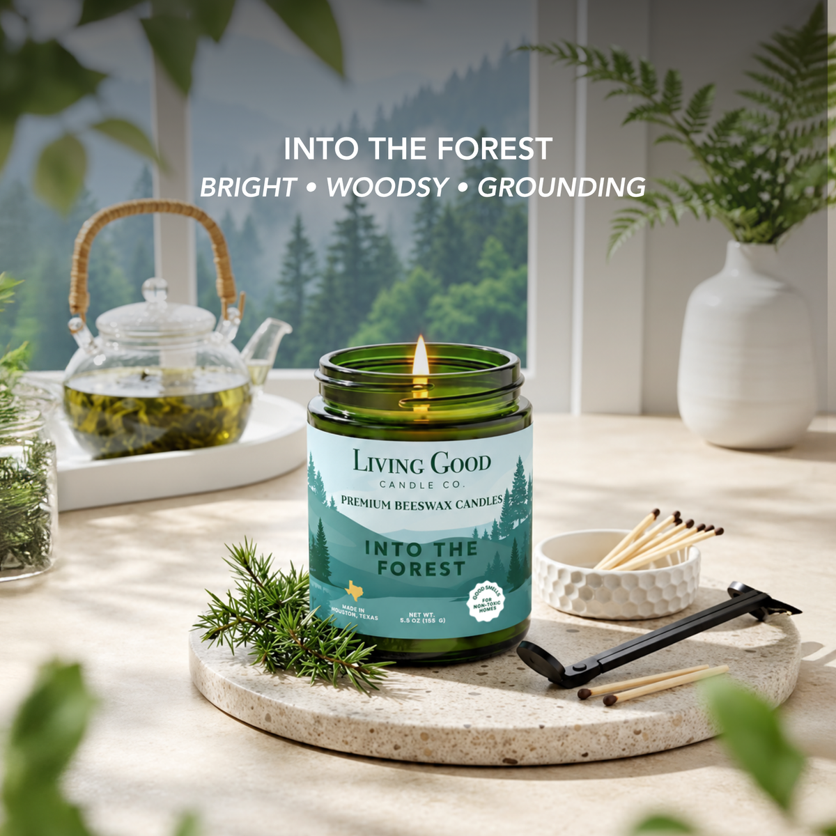 Into the Forest 5.5 oz beeswax candle in a bright botanical setting highlighting its woodsy, grounding scent profile.