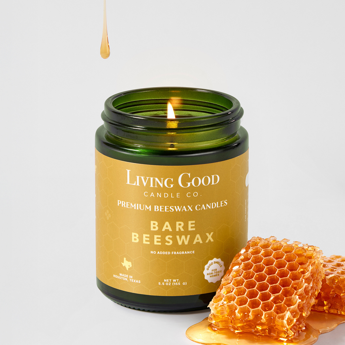 Living Good Candle Co. Bare Beeswax fragrance-free candle made with American beeswax and coconut oil beside natural honeycomb.