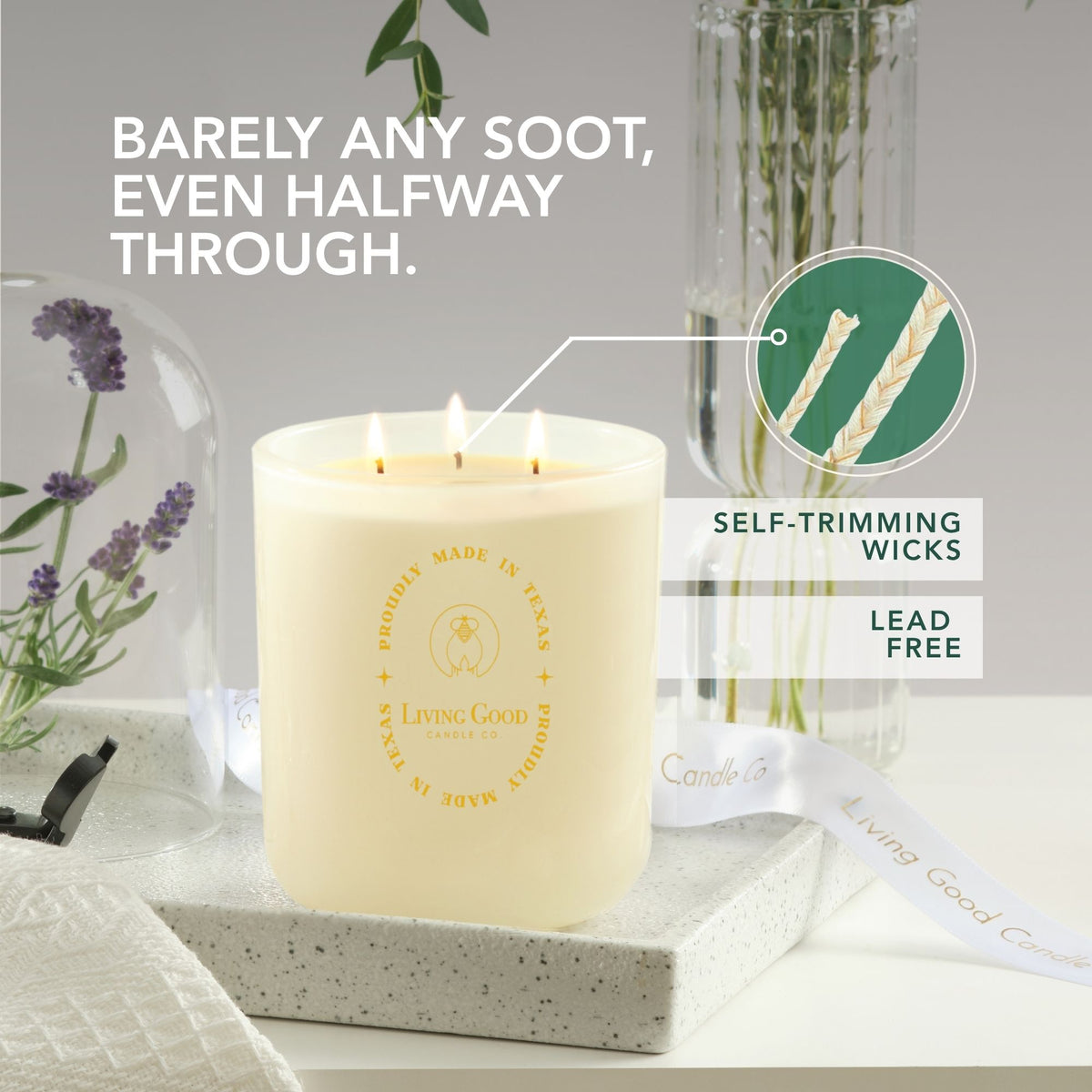 Claricomb beeswax candle with three lit wicks highlighting self-trimming wicks in a bright floral setting