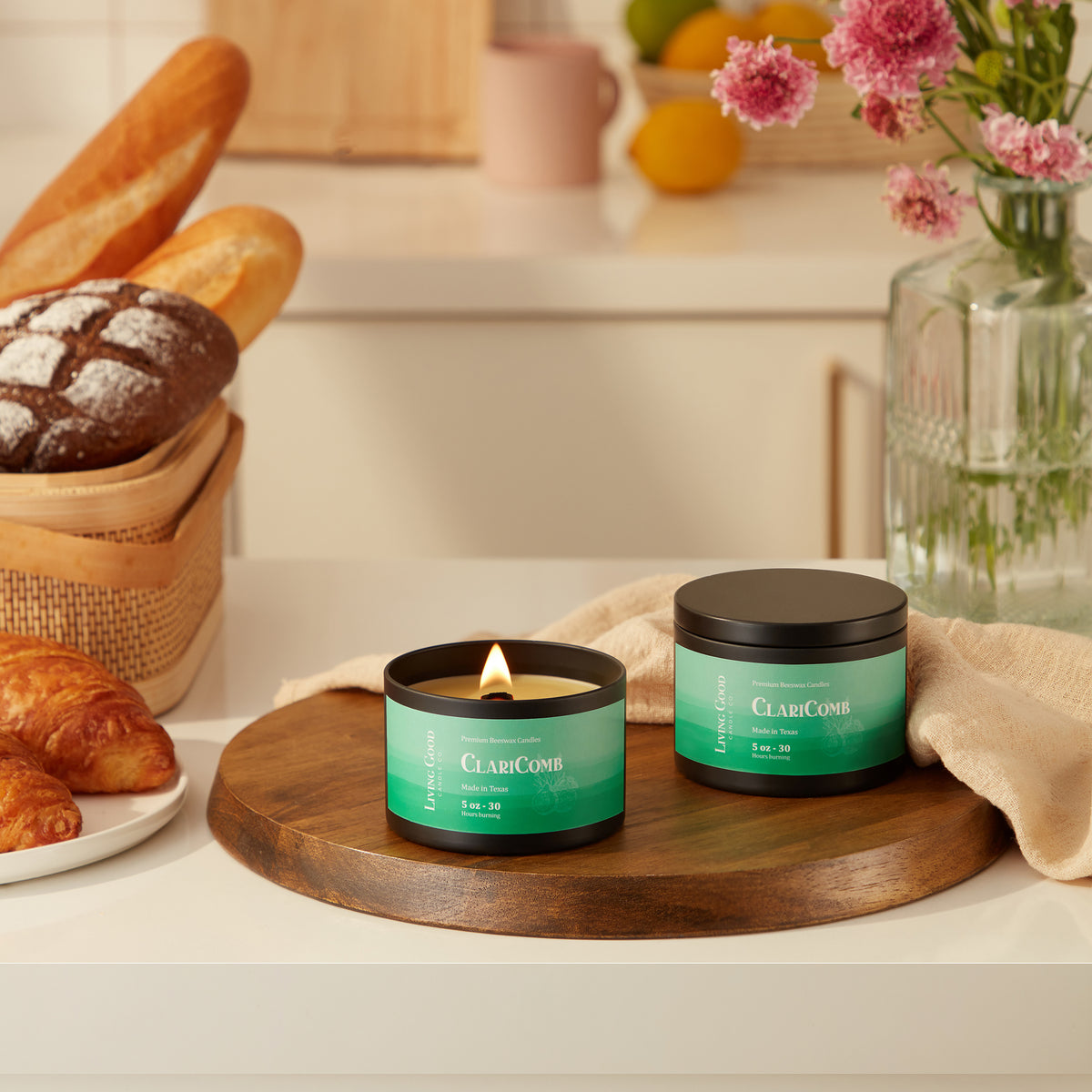 Claricomb candles displayed in green jars with a lit candle, featuring the bergamot and lavender scent
