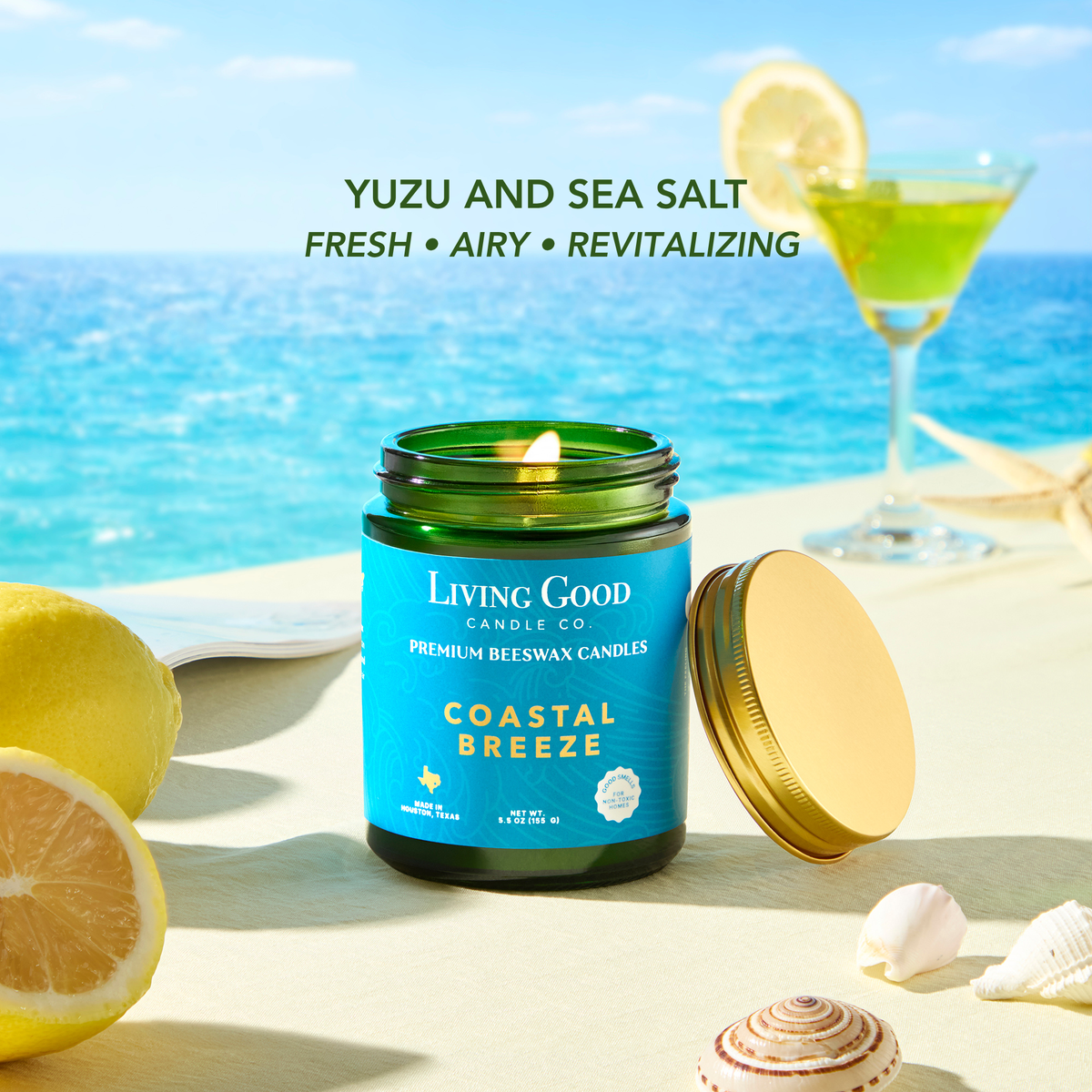 Coastal Breeze beeswax candle with yuzu and sea salt inspiration beside lemon and a bright ocean backdrop.
