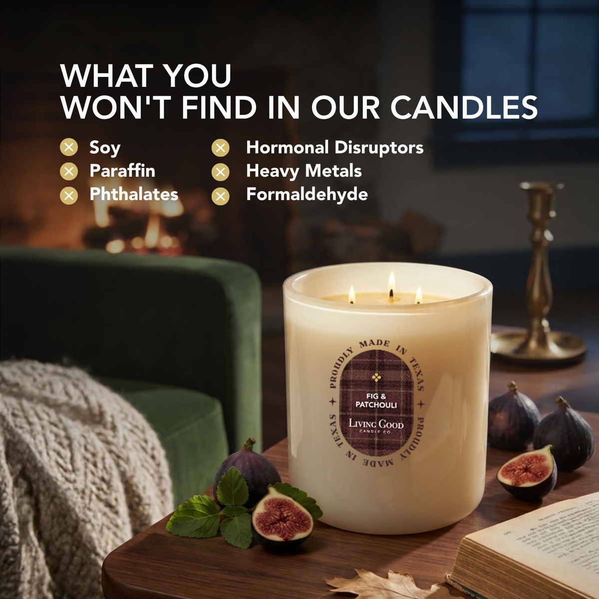 Living Good Candle Co.'s Fig & Patchouli 15oz three-wick beeswax candle lit on a wooden table with fresh figs, an open book and a green velvet chair