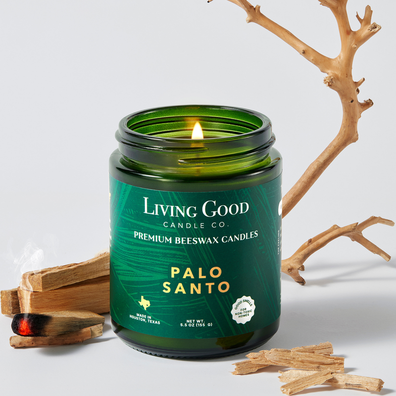 Palo Santo 5.5 oz beeswax candle in a green glass jar with palo santo wood and a lit wick