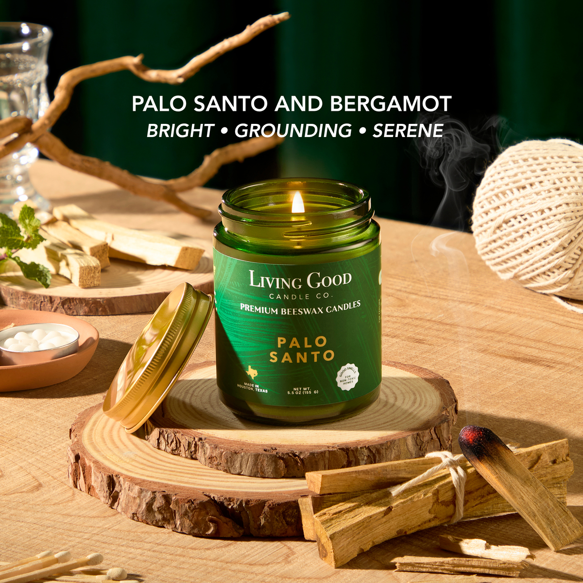 Palo Santo beeswax candle surrounded by palo santo wood, with bergamot and orange notes highlighted