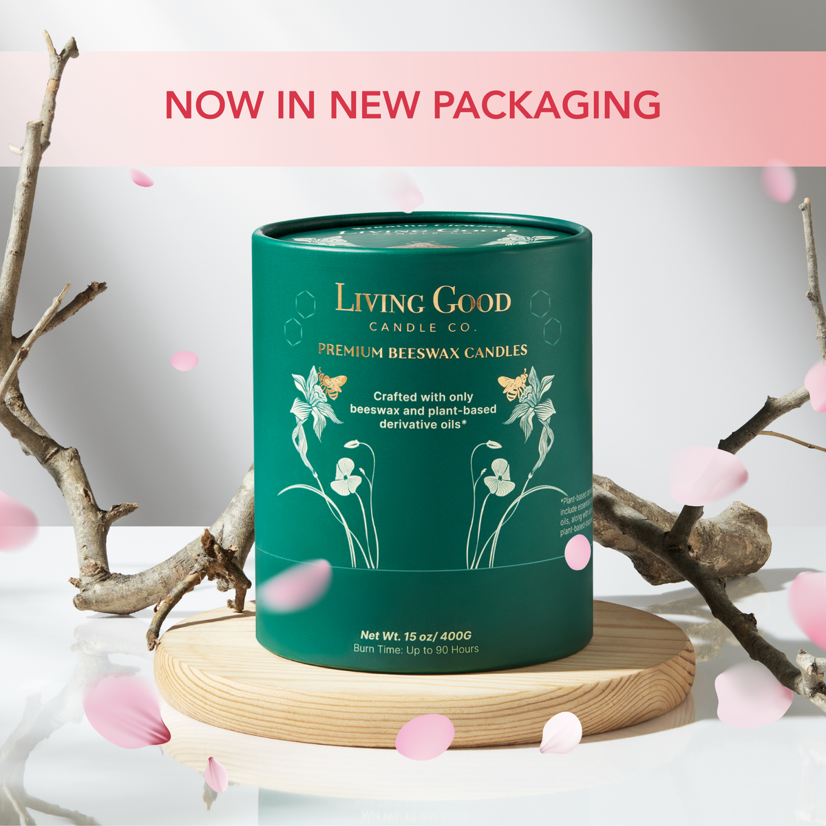 Rose Gulora beeswax candle in new green packaging displayed on a wooden stand with pink flower petals